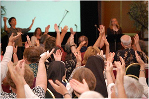 group of people at church with arms raised