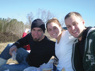 Brother Patrick Cousins, S.C. and Syracuse University student volunteers Kristin Girouard and David Gay take a break from planting cypress saplings