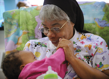 Soeur Brenda Cherry, O. S. P. berce Azariah Yarbrough-Hutchins. Soeur Brenda est directrice du Mt. Providence Child Development Center.