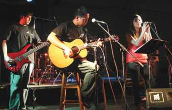 El hermano Nich Pérez, C.S.C. (centro) tocando jazz con los estudiantes Roman Sánchez y Alyssa Sánchez Bernal, de la Holy Cross (Santa Cruz) de San Antonio, la escuela donde enseña, en un concierto llamado Noche Acústica, que él promovió.