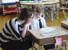 Brittany (at left), a volunteer, and a first-grade student at Nazareth Hall.