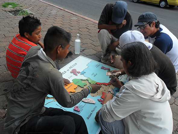 Sister Lupita Silva, C.D.P. and volunteers review geography with middle-school students.