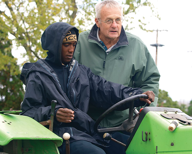 Brother Nick Renner, C.PP.S. with a young man from Chicago who is learning to use a tractor. 