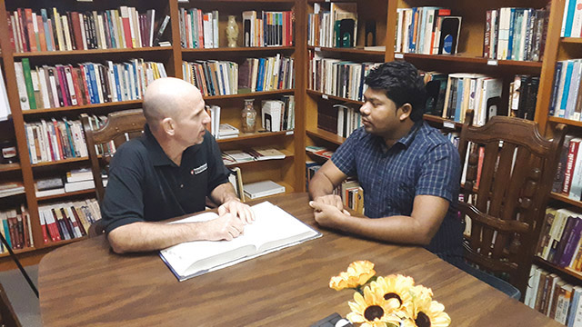 Brother John Skrodinsky, S.T. (left) is pictured here talking about his legal work with one of the men in formation with his community.