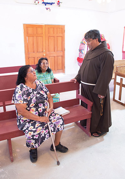 Father Ponchie Vásquez, O.F.M. takes time to check in with parishioners