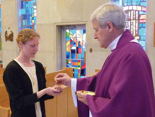 Sister Ana Dura, C.S.R. receives the Body of Christ.