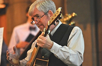 Composer Steve Warner playing guitar at liturgy