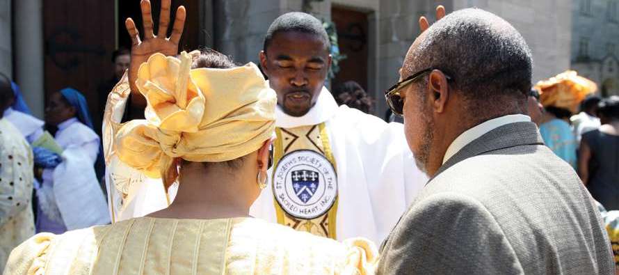 Father Michael K. Okechukwu, S.S.J. blesses a couple at his 2011 ordination