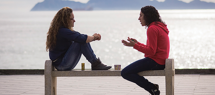 two young women talking on bench