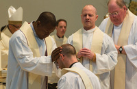 Father Paddy Gilger, S.J. receives blessings from fellow Jesuits during his ordination Mass.