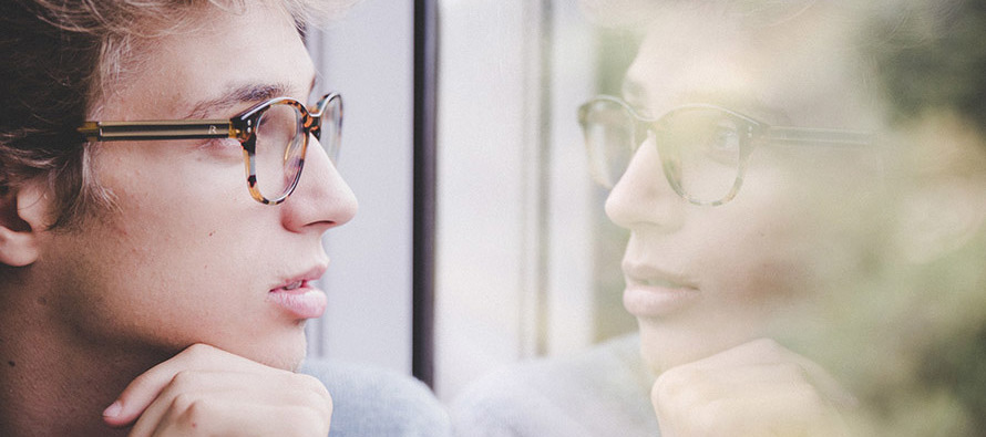 Young man gazing out window