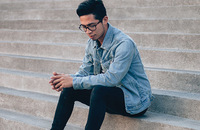 young man sitting on steps looking pensive
