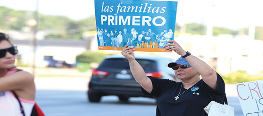 Sister Joni Luna, S.P. (left) takes part in a demonstration of solidarity with migrants, immigrants, and refugees.