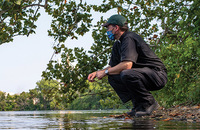 Father Terry Ehrman, C.S.C. with a student from his aquatics biology class collecting water samples. 