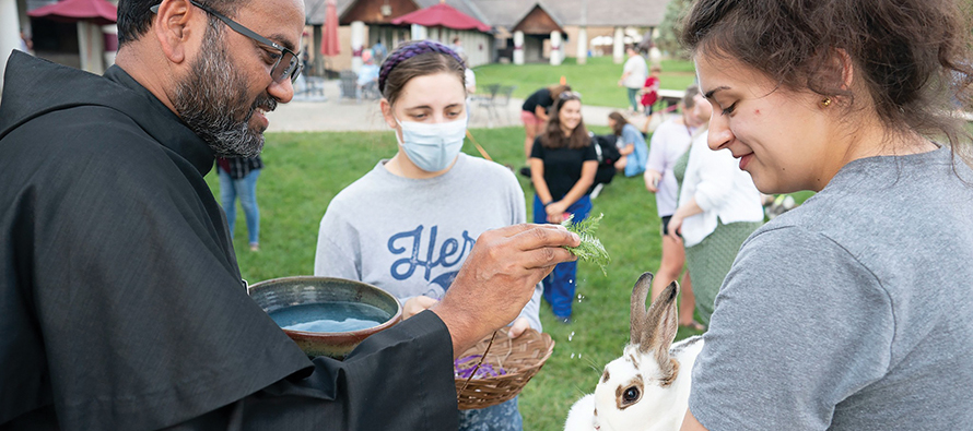 Friar George Munjanattu, O.F.M.Conv., a campus minister at Bellarmine University, blesses a university student’s rabbit on the Feast of St. Francis of Assisi.