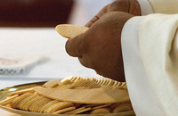 hands holding the Eucharist at an altar